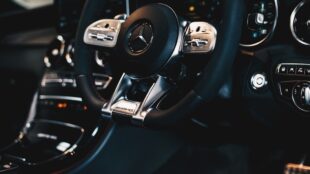 Detail van een AMG-stuurwiel en dashboard met bedieningsknoppen