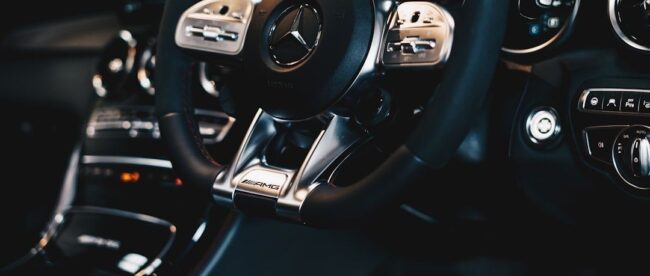 Detail van een AMG-stuurwiel en dashboard met bedieningsknoppen